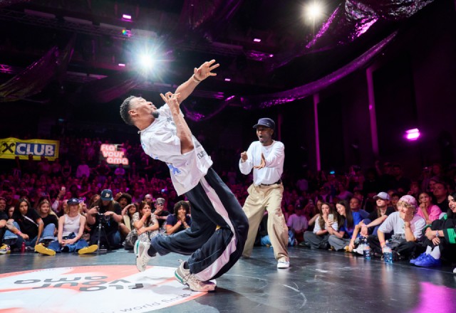 Tänzer bei einer Breakdance-Weltmeisterschaft in Wien, Österreich, mit Publikum im Hintergrund.